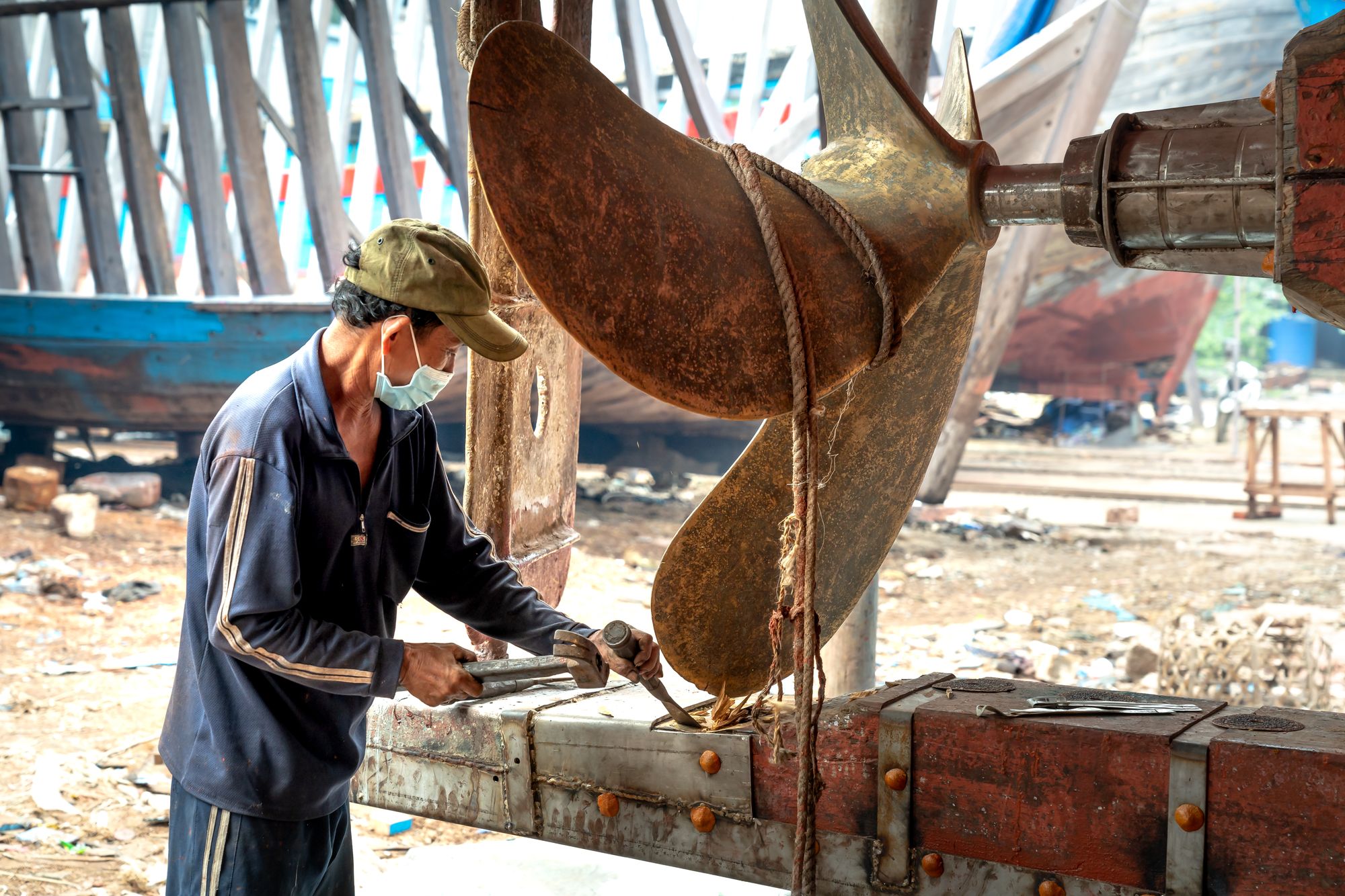 Marine technician carrying out hands-on propeller repair in a shipyard