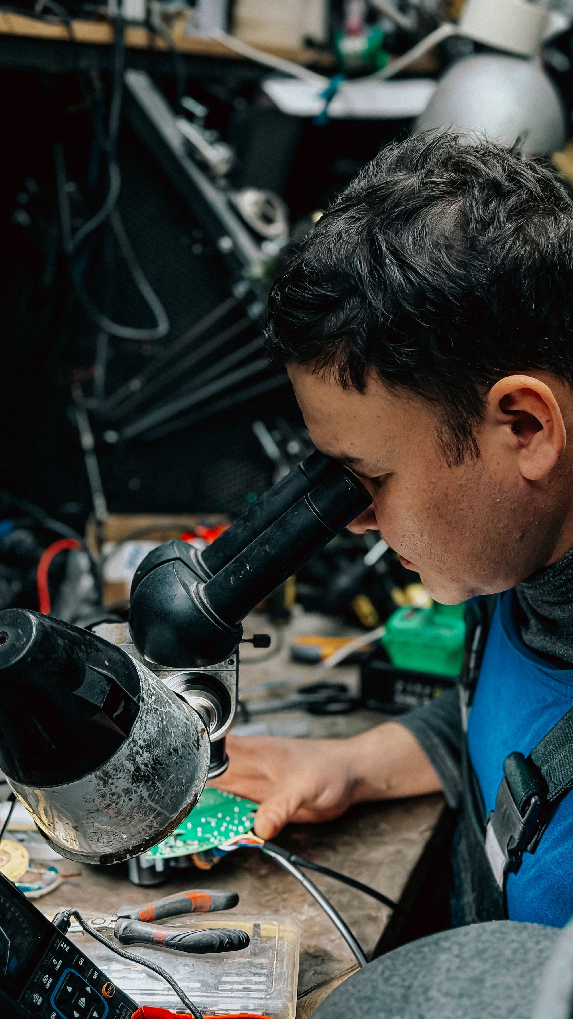 Technician performing detailed quality inspection on an electronic component