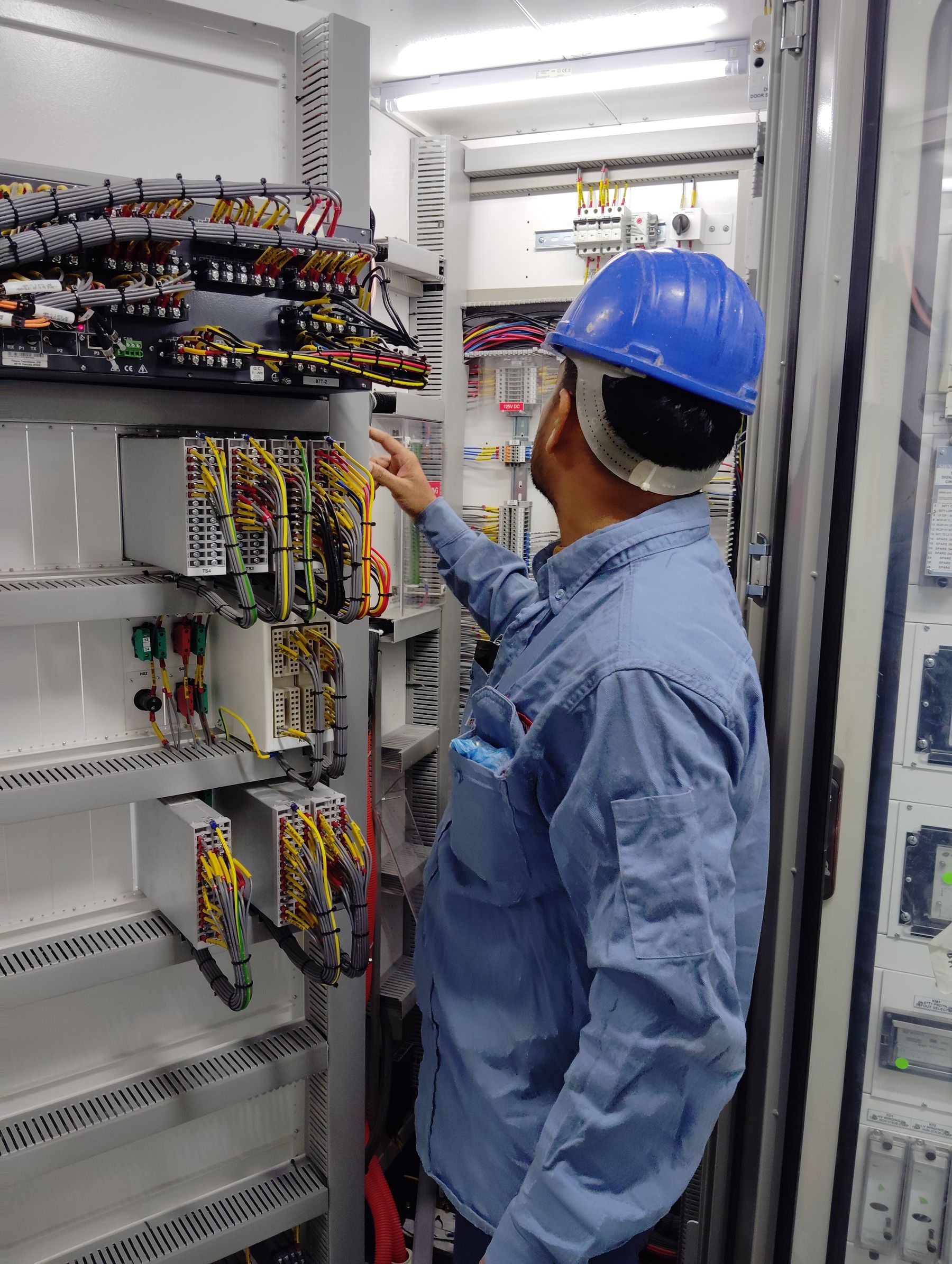 Electrical technician servicing an industrial control cabinet
